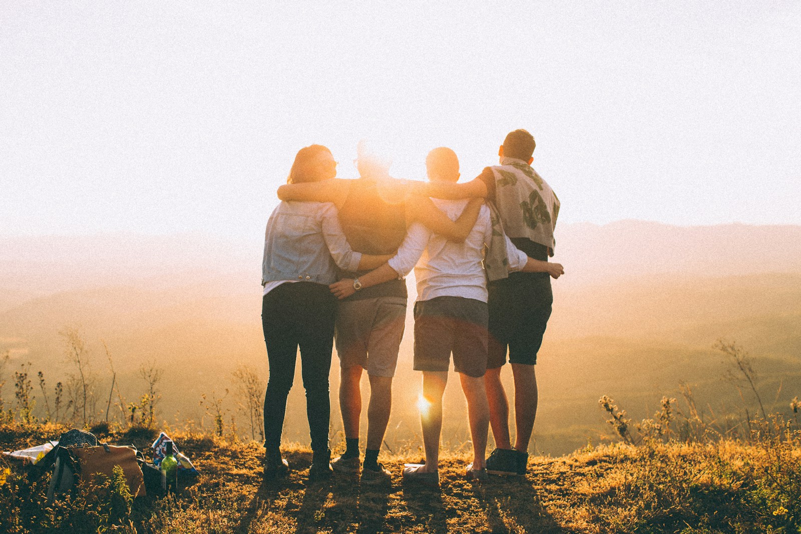 Vorteile von Freundschaften in einer digitalisierten Welt - Vier junge Menschen blicken gen untergehender Sonne.